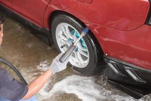 Autowaschreinigung mit Schaum und Hochdruckwasser foto