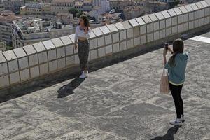 marseille, frankreich, 2022 - zwei junge frauen machen smartphonefotos vor der skyline von marseille. foto