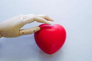 Die Roboterhand berührt ein rotes Herz. Medizintechnik und Zukunftskonzept. foto