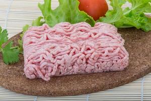 Rohes Schweinehackfleisch auf Holzbrett und Holzhintergrund foto