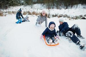 mutter, die mit kindern in der winternatur spielt. draußen im Schnee. foto
