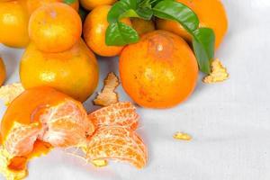 frische orange mit blättern lokalisiert auf weißem stoffhintergrund foto