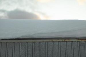 Schnee auf dem Dach. große Schneeschicht auf dem Haus. foto
