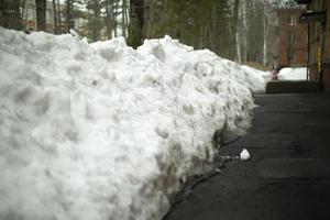 viel Schnee in der Nähe des Hauses. Schneeberg draußen. von Sedimentpfad befreit. foto