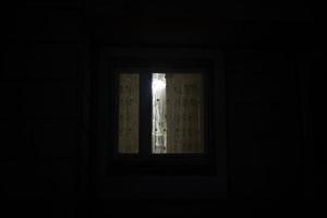 Fenster ist dunkel. Vorhänge am Fenster in der Nacht. foto