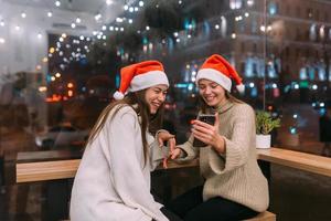 Zwei junge Mädchen mit Smartphone im Café. foto