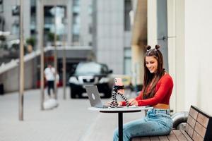 Bloggerin in einem Sommercafé, das auf der Straße streamt. foto