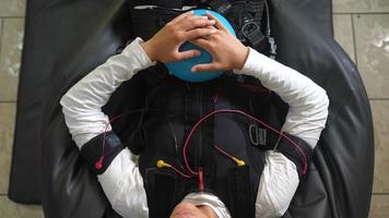 ems-Training. das mädchen liegt in einem anzug mit kabeln. foto