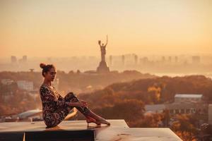 Frau beim Yoga auf dem Dach eines Wolkenkratzers in der Großstadt. foto