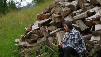 Frau im Wald in der Nähe der Stange aus gehacktem Holz foto