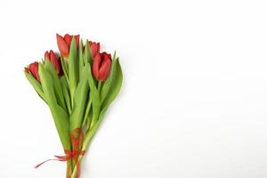 rote tulpen, die auf einem weißen hintergrund für feiertage liegen foto