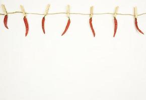 rote Peperoni hängen an einer Schnur. Platz kopieren foto