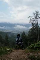Frau auf einem Hügel, vor dem Hintergrund eines Tals foto