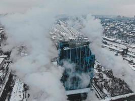 großer zentraler Heizraum mit riesigen Rohren, aus denen im Winter bei Frost in einer Großstadt gefährlicher Rauch entsteht foto