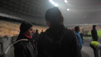 die menschen gehen bei regnerischem wetter im nachtstadion zum sport foto