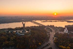 kiewer skyline über schönem feurigem sonnenuntergang, ukraine. Denkmal Mutterland. foto