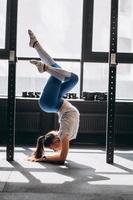 Porträt einer attraktiven jungen Frau, die Yoga- oder Pilates-Übungen macht foto