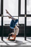 Porträt einer attraktiven jungen Frau, die Yoga- oder Pilates-Übungen macht foto