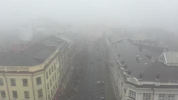 Nebelige Stadtstraße mit Silhouetten von Wohngebäuden. foto