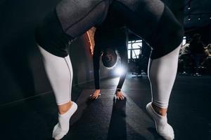 schlanke athletische frau, die im fitnessstudio eine übungsbrücke macht foto