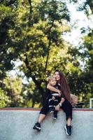 schöne junge Hipster-Mutter und kleiner Sohn im Skatepark foto