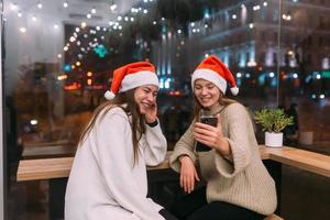 Zwei junge Mädchen mit Smartphone im Café. foto