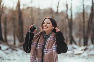 frau, die musik mit ihrem handy hört foto