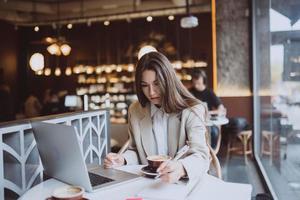 junge Dame, die im Café im Internet surft foto