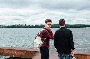 Zwei junge Männer stehen auf dem Pier foto