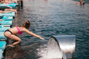 attraktive junge Frau im Bikini, die sich darauf vorbereitet, in den Pool zu springen foto