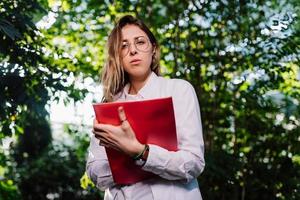 Junger Agraringenieur, der im Gewächshaus arbeitet. junge wissenschaftlerin, die in die kamera schaut foto