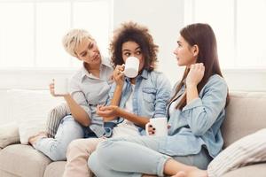drei junge Freundinnen mit Kaffee im Chat zu Hause