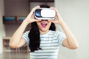 Porträt der asiatischen Frau, die Schutzbrille der virtuellen Realität im Bibliotheksraum spielt, Technologie vr Konzept foto
