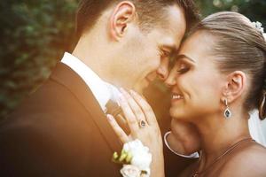 schönes hochzeitspaar, das im park aufwirft foto