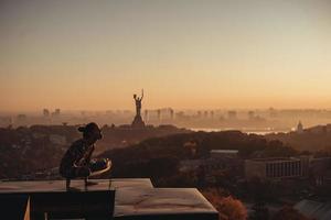 Frau beim Yoga auf dem Dach eines Wolkenkratzers in der Großstadt. foto