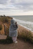 junge Frau an der kalten Herbstküste, die in die Kamera posiert foto