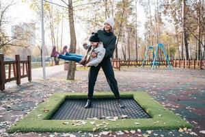 mutter und ihre tochter springen zusammen auf dem trampolin im herbstpark foto