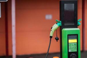 Schließen Sie das Netzkabel für Elektroautos. grüner Bahnhof foto