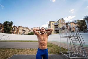 muskulöser Typ mit nacktem Oberkörper im Outdoor-Street-Fitnessstudio. foto