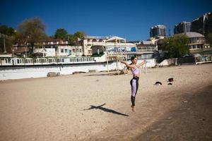 Schöne Frau an einem öffentlichen Strand nach dem Training mit sportlichem Look foto