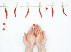 Frauenhände halten eine rote Paprika in der Hand als Symbol der Liebe foto