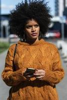Porträt der attraktiven Afro-Frau mit Handy in der Straße