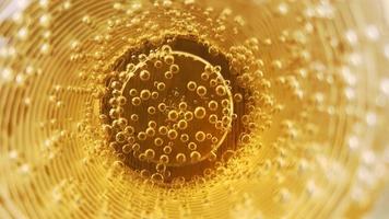 abstrakter hintergrund der goldenen flüssigkeit in einem glas voller luftblasen. foto