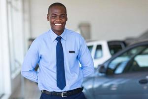 afroamerikanischer Verkäufer, der am Fahrzeugausstellungsraum arbeitet