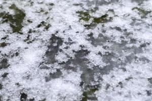 Schmutzige Schneespuren auf Asphalt auf einer kleinen deutschen Straße foto