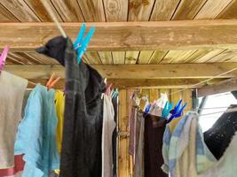 Wäsche, die auf einer Wäscheleine zum Trocknen aufgehängt und mit Wäscheklammern befestigt wird foto