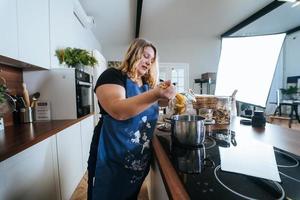 kochen - frau in der modernen küche, spaghetti zubereitend foto