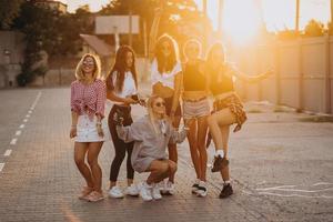 Sechs junge Frauen tanzen auf einem Parkplatz foto