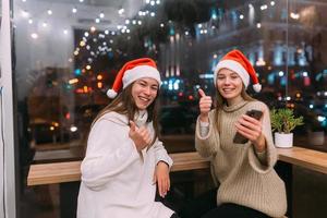 Zwei junge Mädchen mit Smartphone im Café. foto