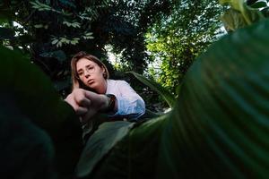 Junger Agraringenieur untersucht Blätter im Gewächshaus foto